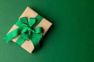 Gift wrapped in brown paper with shiny green bow.